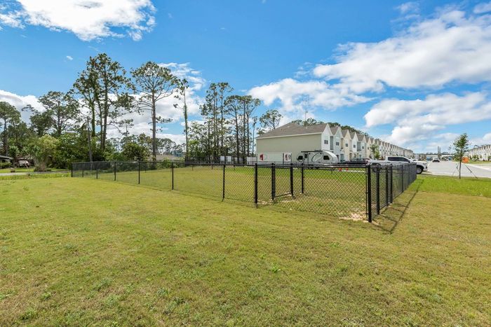 Outdoor dog park with fenced in area and green grass