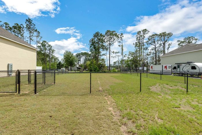Outdoor dog park with fenced in area and green grass