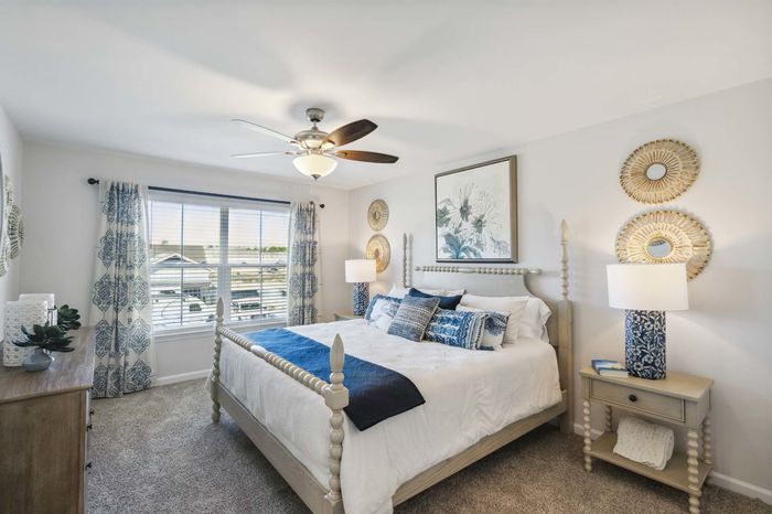 Furnished bedroom with sunlit windows