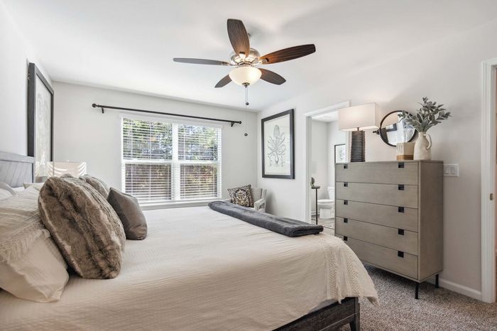 Furnished bedroom with sunlit windows