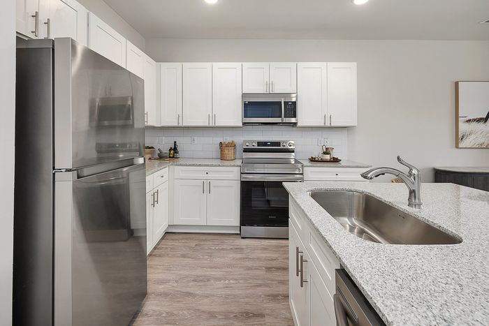 Kitchen with stainless steel apartments and white cabinets
