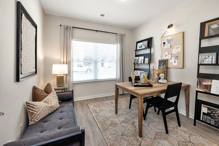 Furnished office area with one window, settee and desk