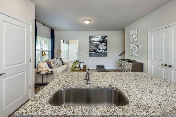 furnished kitchen and living room area with island and appliances in single-family home