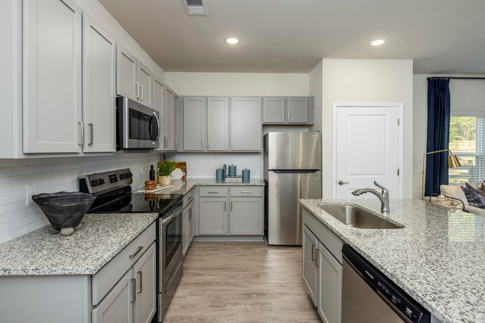 furnished kitchen area with island and appliances in single-family home