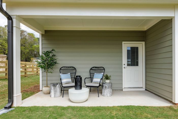furnished backyard patio area of single-family home on sunny day