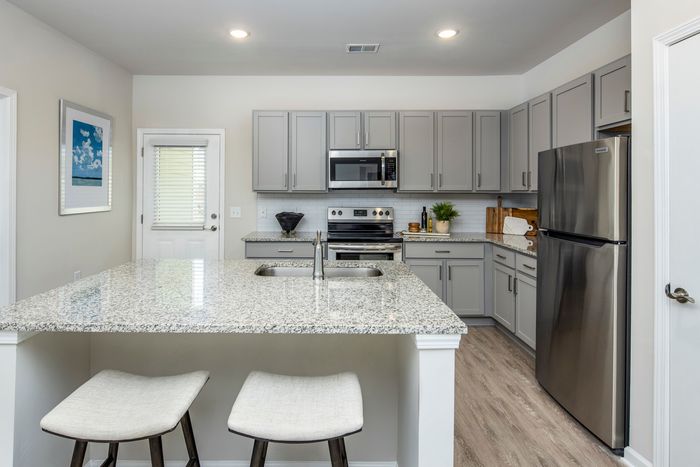 furnished kitchen area with island and appliances in single-family home