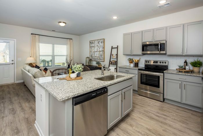 furnished kitchen area with island and appliances in single-family home
