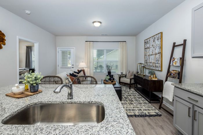 furnished kitchen and living room area with island and appliances in single-family home