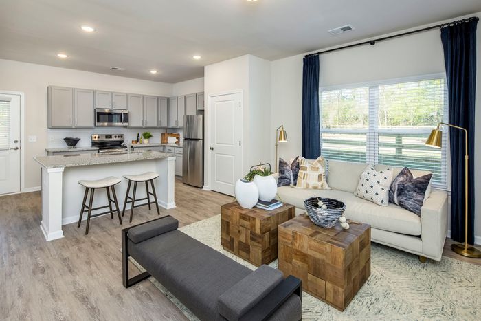 Loganville Homes for Rent - Cottages at Loganville - Living Room with Spacious Windows, Neutral Couch, and Cubed Coffee Tables