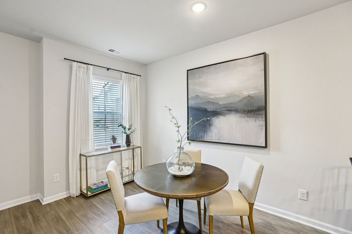 Dining room with furniture, large window with blinds, and wood-style flooring in Lawrenceville, GA