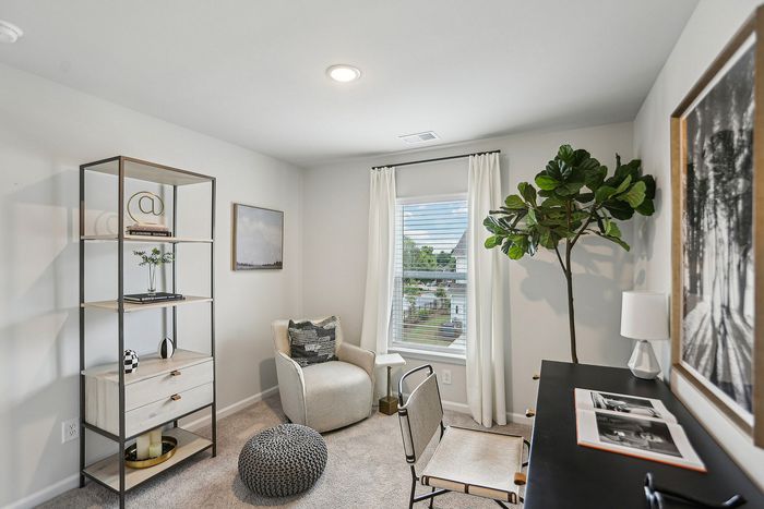 Furnished bedroom with desk and chair with window and carpeted flooring