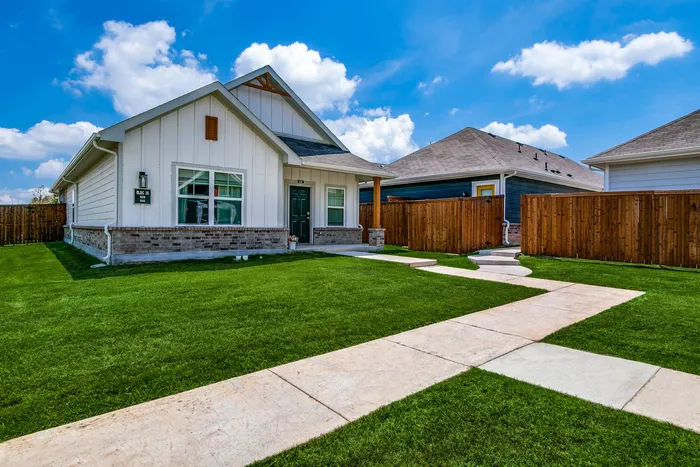 Houses for Rent in South Fort Worth, TX - Cottages at Summer Creek - outside image of home with sidewalk, green lawn, porch, and a dividing fence