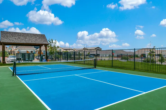 South Fort Worth, TX Rental Homes - Cottages at Summer Creek - a green and blue tennis court with fencing and a gazebo
