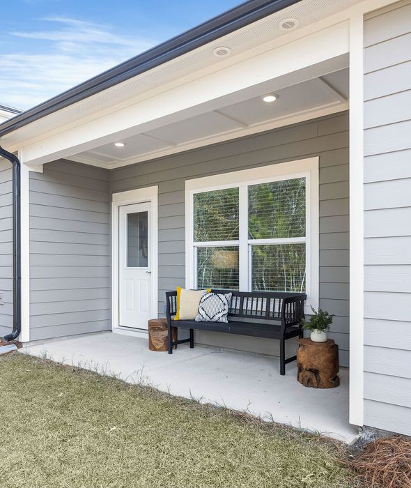 Charming front porch with cozy seating and lush greenery, perfect for relaxing outdoors at home.