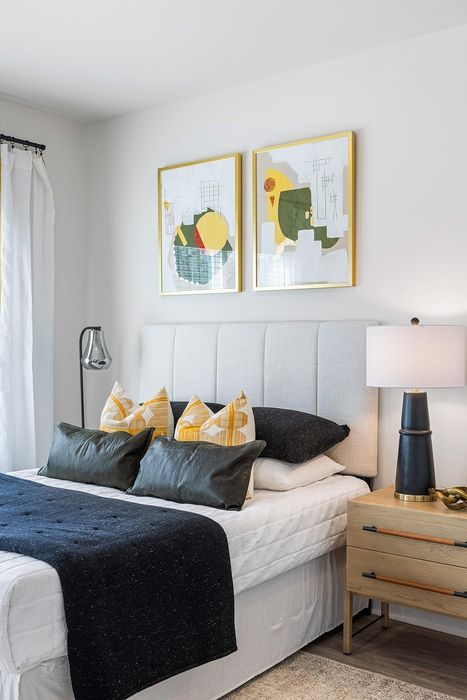 Chic bedroom with modern art, plush pillows, and elegant lighting, exuding contemporary comfort.