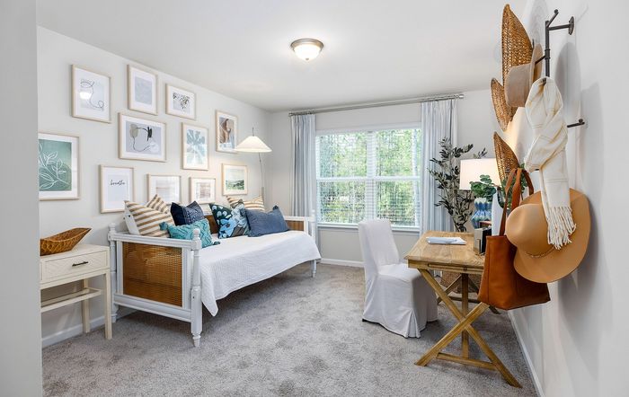 Bright and inviting study room showcasing stylish decor, a comfortable daybed with colorful pillows, and a cozy workspace with natural light.