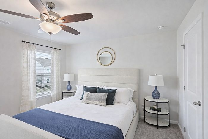 Inviting bedroom with plush bed, elegant bedside lamps, and serene decor, perfect for relaxation.
