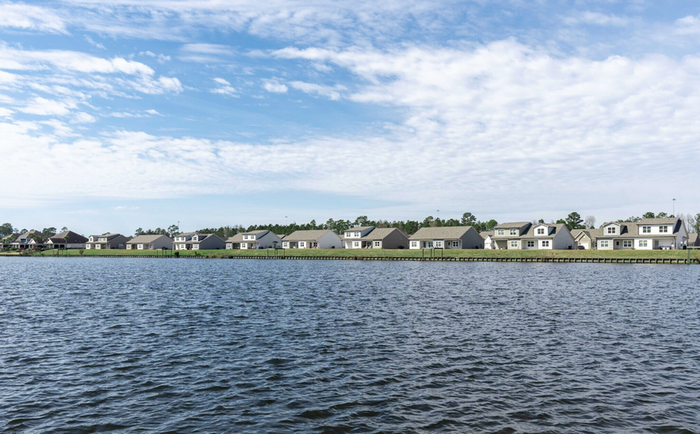 Lake on a sunny day with homes in the background