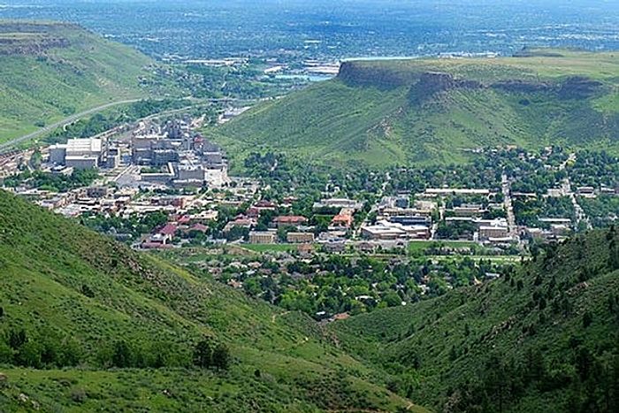 Aerial view of a vibrant city surrounded by lush green hills and a sprawling landscape.