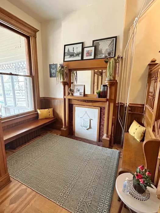 Cozy corner featuring a vintage wooden bench, elegant fireplace, and stylish photo decor.