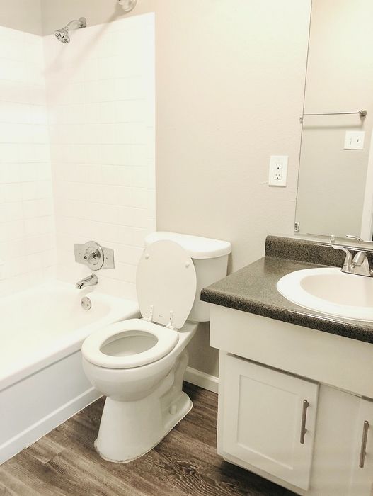 Modern bathroom with elegant design, featuring a sleek countertop, pristine bathtub, and contemporary flooring.