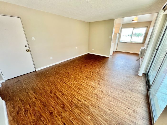 Bright and airy living space with stylish wood flooring, large windows, and an open layout perfect for modern living.