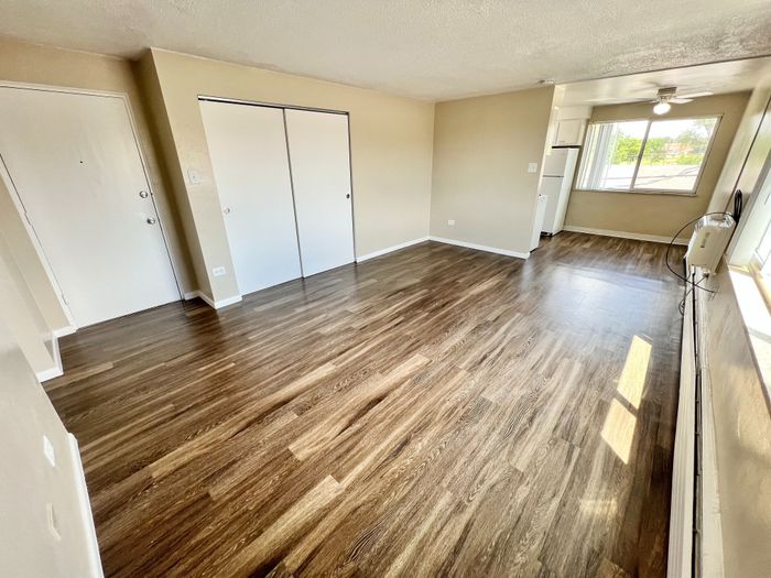 Bright and spacious apartment with beautiful wood flooring and ample natural light, offering a modern open layout.