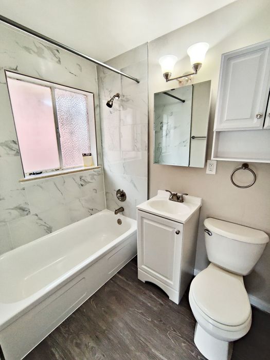 Modern bathroom with elegant marble tiles, stylish fixtures, and a pristine bathtub for a luxurious feel.