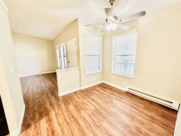 Bright and welcoming living space with elegant wooden floors and large windows for natural light.