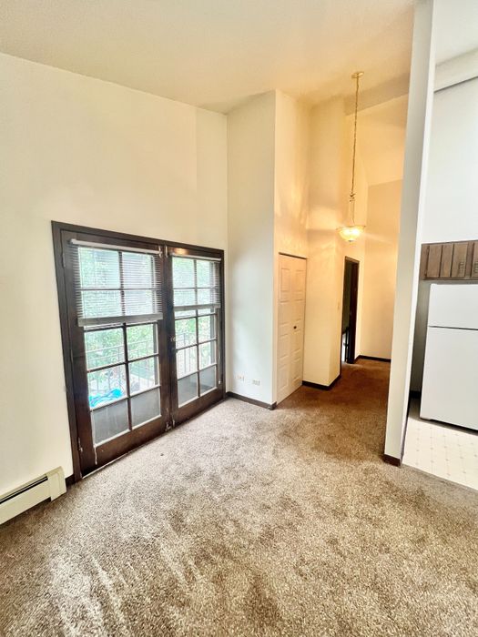 Inviting living space with plush carpet, elegant French doors, and warm ambient lighting.