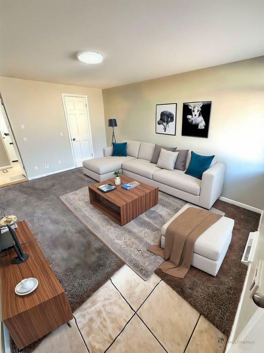 Inviting living room with plush carpet, stylish sectional sofa, contemporary artwork, and modern wooden furniture.