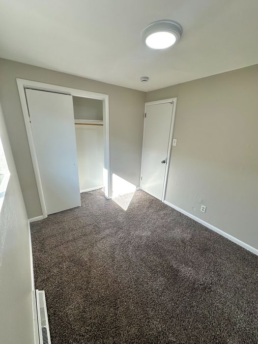 Bright and cozy room with plush carpeting and ample closet space, perfect for a peaceful retreat.