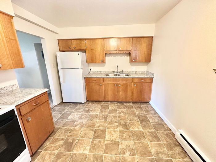 Cozy kitchen with warm wooden cabinetry, sleek countertops, and modern appliances, perfect for culinary creativity.