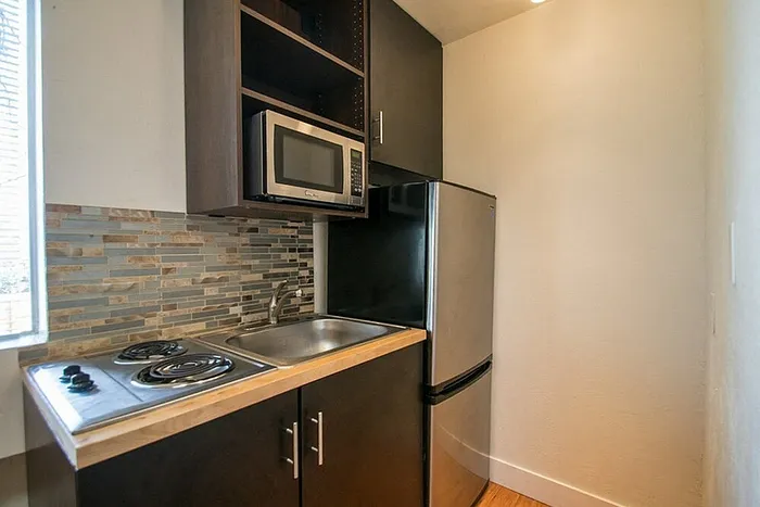 Chic kitchenette with modern appliances and stylish tile backsplash, perfect for efficient cooking.