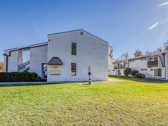 Charming apartment building with modern architecture, nestled in a serene neighborhood with lush green lawns.