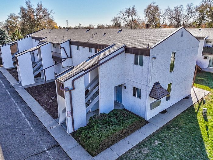 Charming suburban apartment complex with modern architecture, featuring crisp white exteriors, and nestled in a serene neighborhood surrounded by lush greenery.