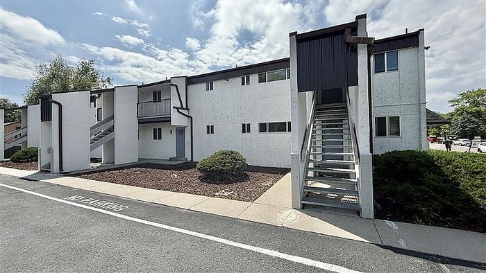 Charming two-story apartment building with modern exterior, featuring unique architectural design and private entrance.