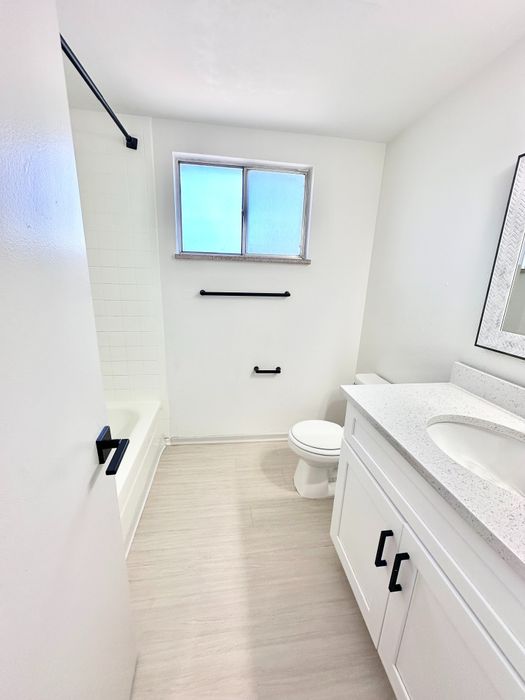Bright, modern bathroom with sleek white cabinetry, elegant fixtures, and abundant natural light.