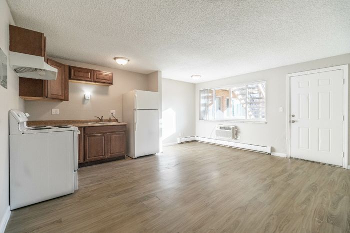Bright and airy open-plan living space featuring a modern kitchen with elegant wood cabinetry and hardwood floors.