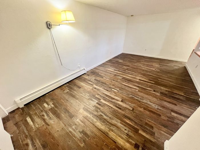 Inviting open space featuring elegant hardwood floors and ambient wall lighting, perfect for a cozy living room setup.