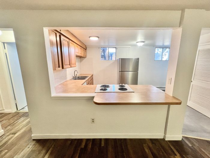 Bright and inviting kitchen with modern appliances, wooden cabinetry, and open countertop. Perfect for enjoying culinary creations and social gatherings.