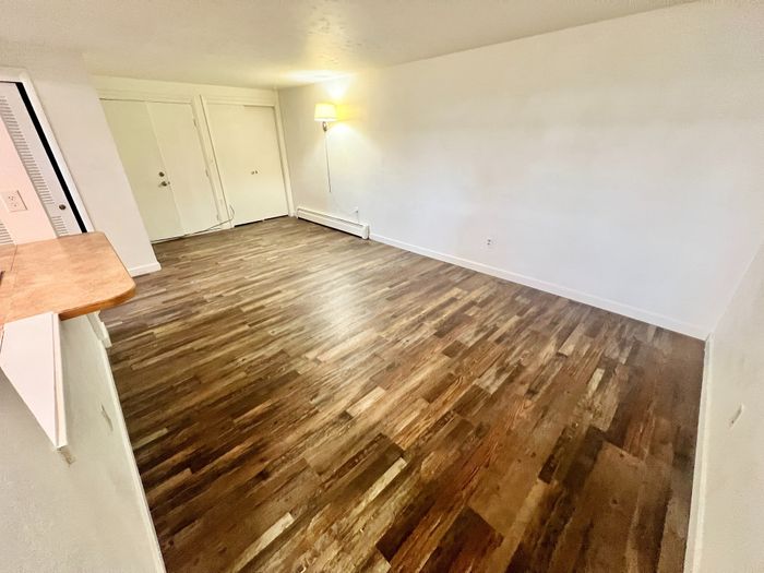 Inviting living space with elegant wood flooring and bright natural light, creating a warm and modern atmosphere.