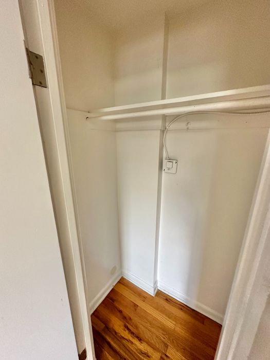 Bright and spacious closet with elegant hardwood flooring, perfect for maximizing storage and organization.