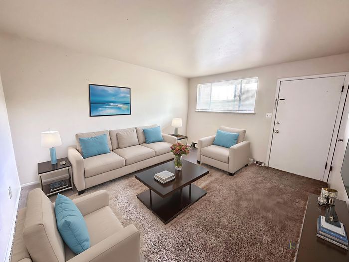 Bright and welcoming living room with cozy beige sofas, elegant decor, and natural light highlighting the open space.
