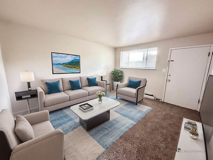 Inviting living room with a comfy sofa, modern decor, and large windows for natural light, perfect for relaxation.