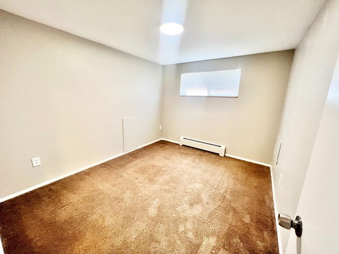Bright and cozy room with soft carpet flooring and ample natural light, perfect for a restful retreat.