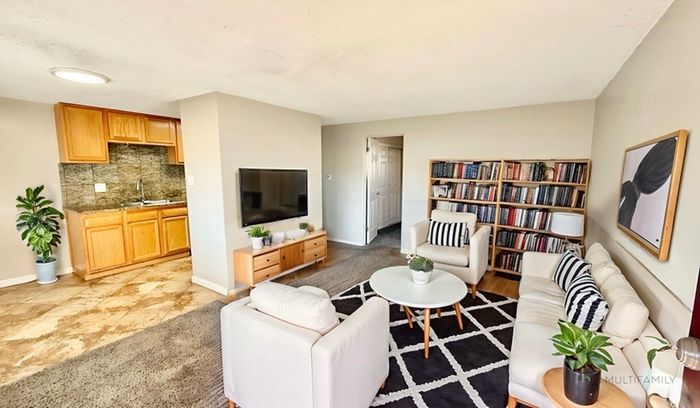 Inviting living room with cozy seating, stylish decor, and integrated kitchen area, perfect for relaxation and social gatherings.