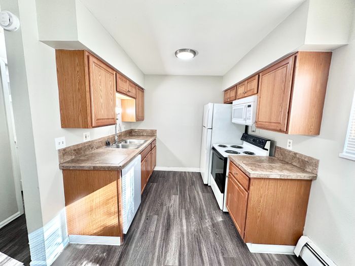 Modern kitchen with sleek countertops, wooden cabinetry, and bright natural light.