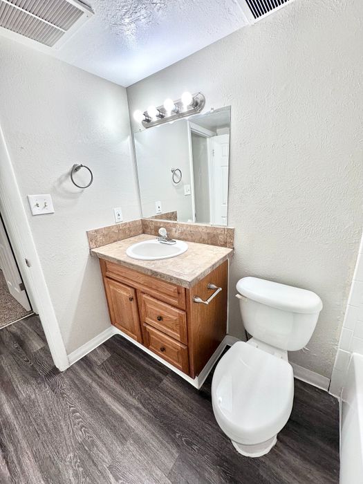 Modern bathroom with elegant wood vanity, sleek countertop, and bright lighting.