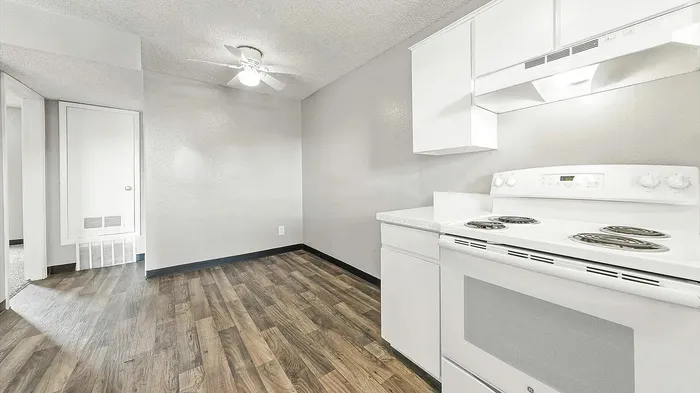 Bright and inviting kitchen with sleek white cabinetry, modern appliances, and elegant wood flooring.